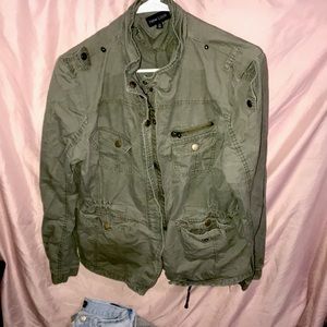 Green sweater.Has multiple zippers and pockets with buttons.Scrunched up in back